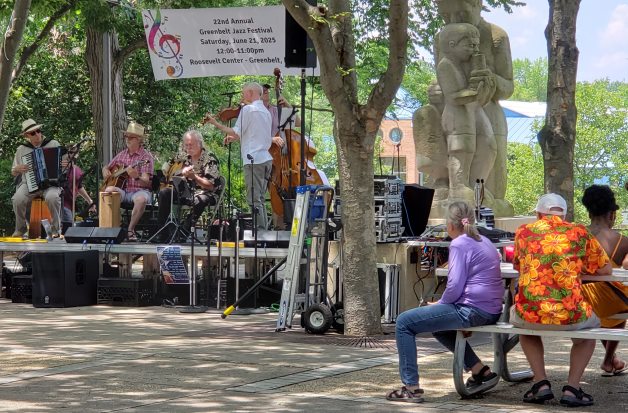 Roosevelt center stage with jazz combo playing,
 plus some audience members; the Mother-and-child statue is visible to one side.
